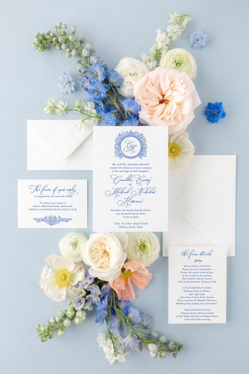 Blue wedding invitation suite featuring floral wedding crest in a classic, elegant style.