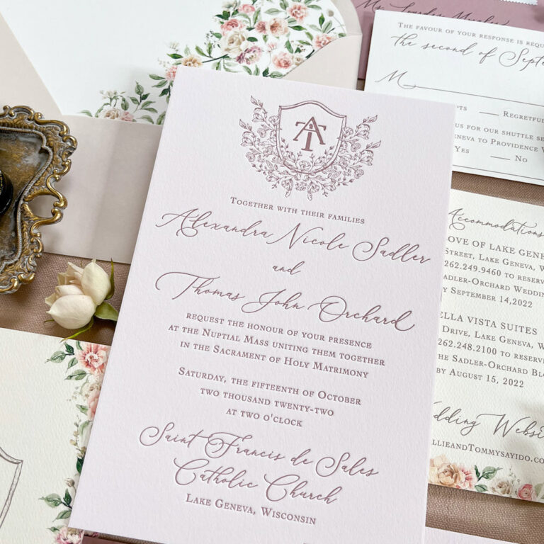 Blush letterpress wedding invitation with floral envelope liner and monogram crest