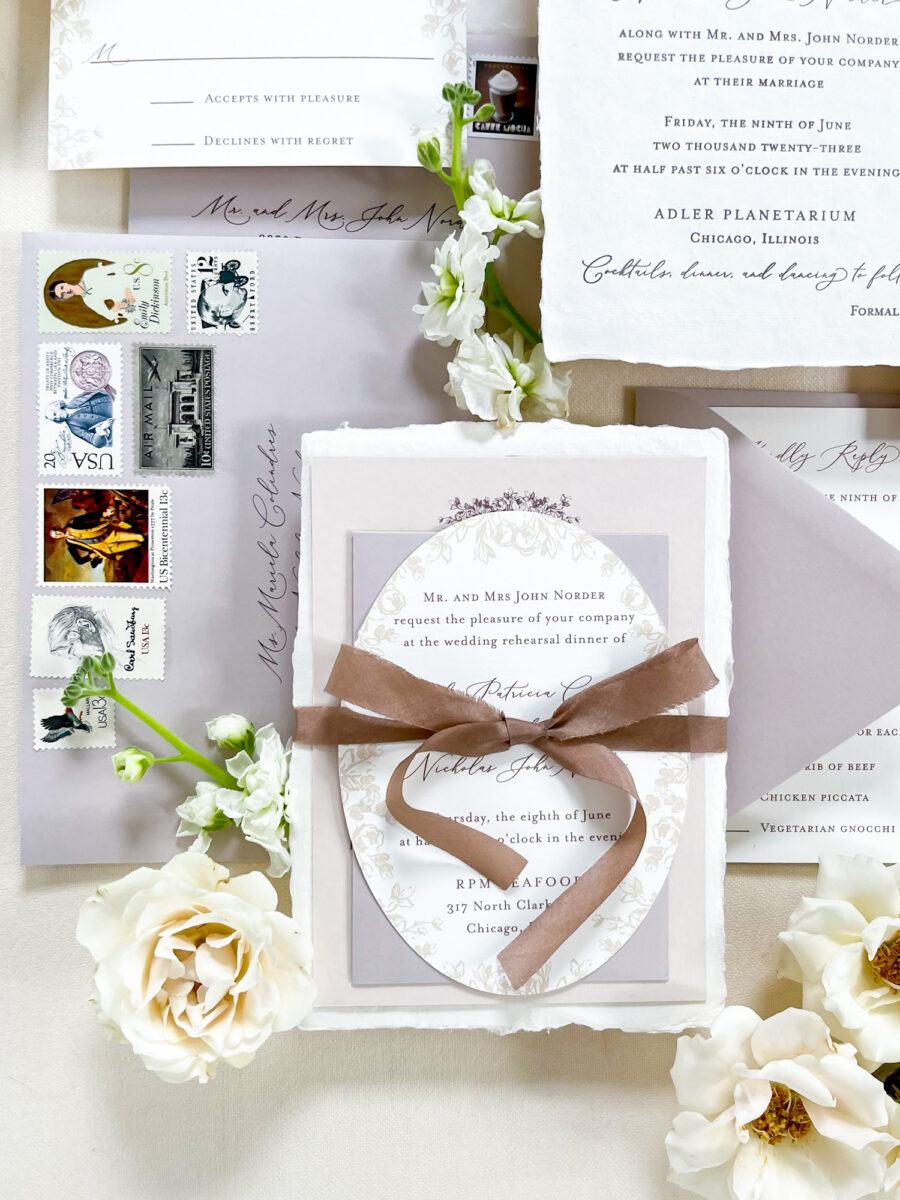 Romantic wedding invitation featuring a whimsical design of oval shape and textures with a silk ribbon and vintage postage.